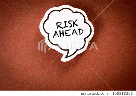 RISK AHEAD. Speech bubble with text on brown background RISK AHEAD. Speech bubble with text on brown background 108818398