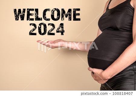 Welcome 2024 Concept. A pregnant woman points to the text Welcome 2024 Concept. A pregnant woman points to the text 108818407