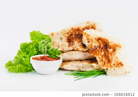 Chicken fillets fried until half cooked, semi-finished product with fresh herbs on a white background. Fast food. Quick cooking at home. Copy space.Fast cooking.Fast homemade food. 108818812