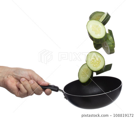 Cucumber fly fall in pan, green fresh vegetable cucumber cut chop slice. Organic fresh vegetable with eaten leaf of long cucumber, close up texture. White background isolated freeze motion high speed 108819172