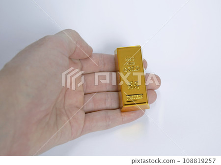 gold bar of the highest standard in a man's hand on a white background 108819257