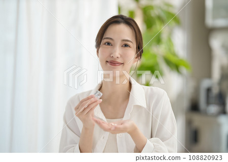 woman taking medicine in the living room 108820923