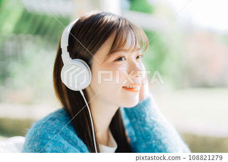 Young woman listening to music on the terrace 108821279