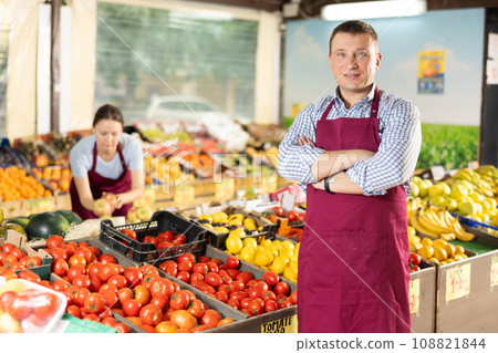 Positive and friendly store man employee stands with arms crossed on chest and waits for customers Positive and friendly store man employee stands with arms crossed on chest and waits for customers 108821844