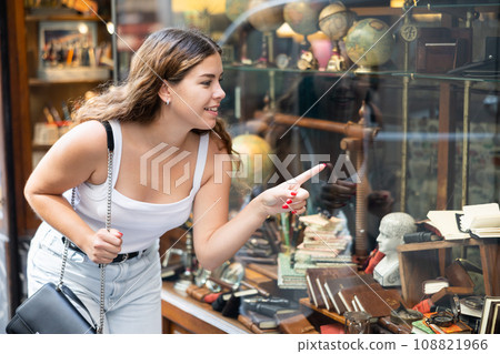Interested young woman viewing retro-style stationery in souvenir store 108821966