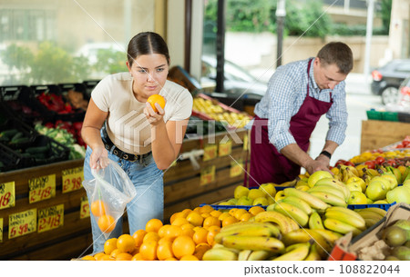 Young female customer made beeline for fresh produce section, pick juiciest oranges Young female customer made beeline for fresh produce section, pick juiciest oranges 108822044