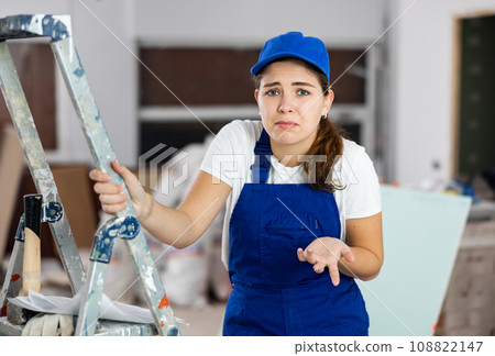 Sad woman builder standing in construction site Sad woman builder standing in construction site 108822147