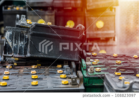 Battery waste danger. Pile of old used EV car batteries toxic waste chemicals lead leak impact nature no recycled. 108823097