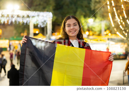 Cheerful girl with flag of Belgium at Christmas city market Cheerful girl with flag of Belgium at Christmas city market 108823130
