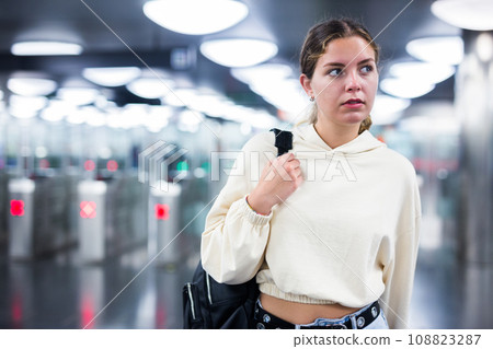 Younh female passing the turnstiles at subway station Younh female passing the turnstiles at subway station 108823287