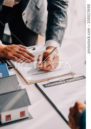 Real estate agent and customer signing contract to buy house, insurance or loan real estate.rent a house,get insurance or loan real estate or property. Real estate agent and customer signing contract to buy house, insurance or loan real estate.rent a house,get insurance or loan real estate or property. 108823698