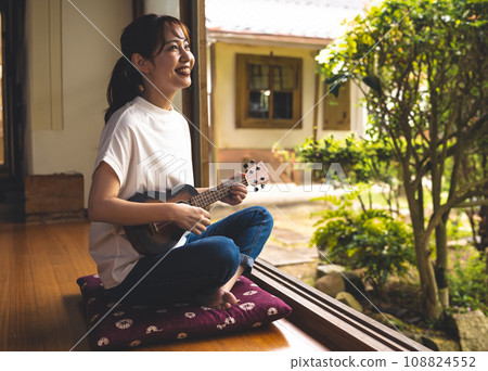 一位女士在日式房間彈奏尤克里裡 108824552