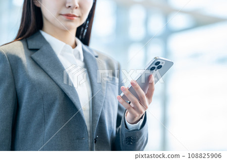 A business person operating a smartphone. (parts) A business person operating a smartphone. (parts) 108825906