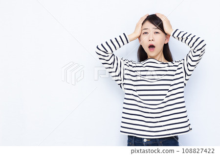 A woman in her 40s holding her head in surprise A woman in her 40s holding her head in surprise 108827422