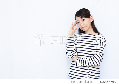 A woman in her 40s who is having trouble holding her temples 108827769