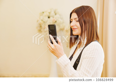 A young woman is filming a wedding ceremony at the registry office.  108828499