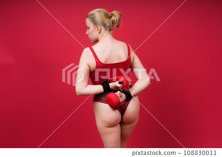 Seductive young and fit female fighter posing in gloves in studio 108830011