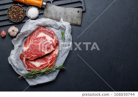 Raw ribeye steaks with savory spices 108830744