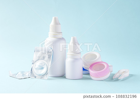 Contact lenses, solution bottle and eye drops with accessories on blue background Contact lenses, solution bottle and eye drops with accessories on blue background 108832196