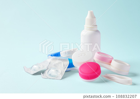 Contact lenses with cases and solution bottle on blue background, copy space Contact lenses with cases and solution bottle on blue background, copy space 108832207