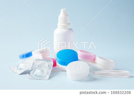 Contact lens solution bottle with contact lenses and cases on blue background Contact lens solution bottle with contact lenses and cases on blue background 108832208