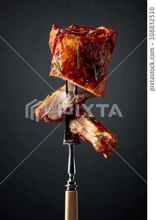 Grilled pork ribs on a fork. 108832510