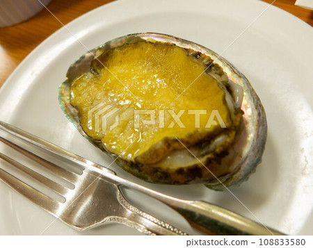Grilled live abalone on a ceramic plate Grilled live abalone on a ceramic plate 108833580