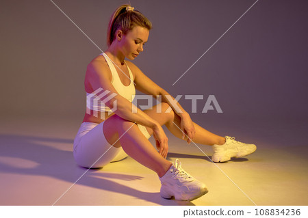 Tired exhausted woman sitting on the floor Tired exhausted woman sitting on the floor 108834236