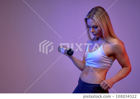 slim body of a young fit sporty woman lifting dumbbells slim body of a young fit sporty woman lifting dumbbells 108834322
