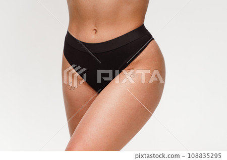 A woman with a beautiful feminine figure in black lingerie with overweight, cellulite and stretch marks. A woman with a beautiful feminine figure in black lingerie with overweight, cellulite and stretch marks. 108835295