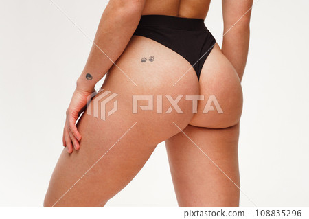 A woman with a beautiful feminine figure in black lingerie with overweight, cellulite and stretch marks.  108835296