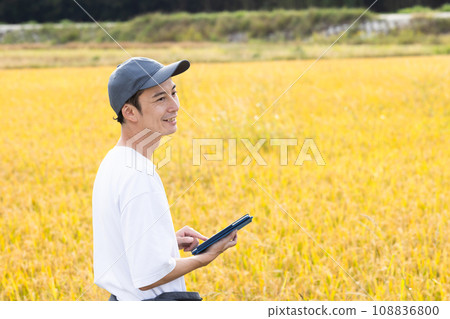 A refreshing man standing in a rice field 108836800