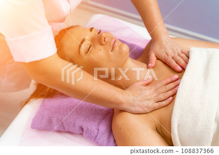 Facial massage. A woman is given a massage in a beauty salon. Close-up. Facial massage. A woman is given a massage in a beauty salon. Close-up. 108837366
