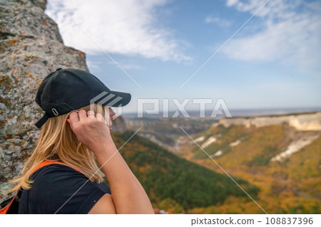 woman backpack on mountain peak looking in beautiful mountain valley in autumn. Landscape with sporty young woman, blu sky in fall. Hiking. Nature 108837396