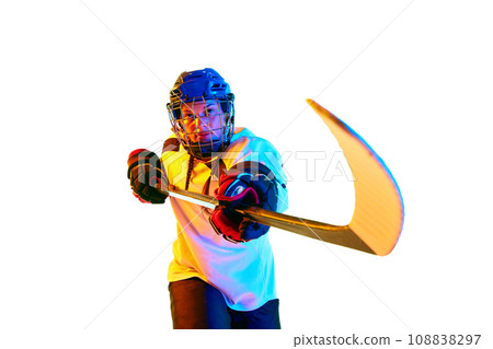 Motivation to win. Young girl, hockey player in helmet and uniform, training, playing against white background in neon light 108838297