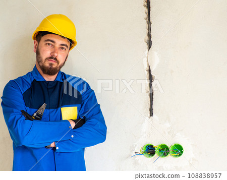 Portrait of worker or engineer in blue work clothes and yellow safety helmet 108838957