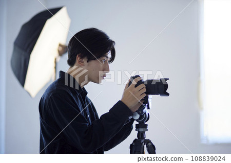 Japanese male photographer taking pictures in a photo studio 108839024