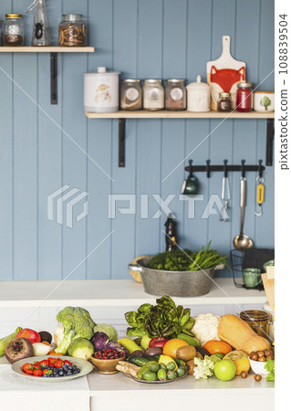Fresh raw healthy food on a white table in the kitchen at a country cottage, indoor, copy space, vertical photo, selective focus. Fresh raw healthy food on a white table in the kitchen at a country cottage, indoor, copy space, vertical photo, selective focus. 108839504