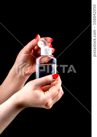 Female hands tear off the cap of a plastic bottle with hand sanitizer gel. Female hands tear off the cap of a plastic bottle with hand sanitizer gel. 108842050
