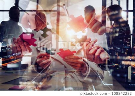 Businessmen working together to build a puzzle as teamwork, partnership and integration concept Businessmen working together to build a puzzle as teamwork, partnership and integration concept 108842282