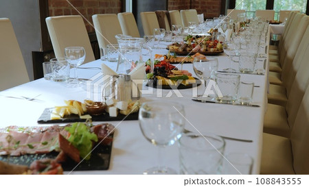 A beautiful festive table covered with a variety of food. Food and drinks on the festive table in the restaurant on birthdays, weddings. Beautifully decorated banquet table with appetizers. 108843555