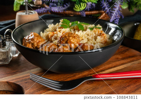 Meatballs pork and mashed potatoein paprika gravy served with groats bulgur. 108843811