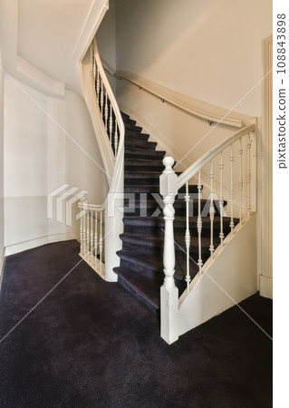 a white staircase with black carpet and wooden handrails in an empty living room photo taken from the inside a white staircase with black carpet and wooden handrails in an empty living room photo taken from the inside 108843898