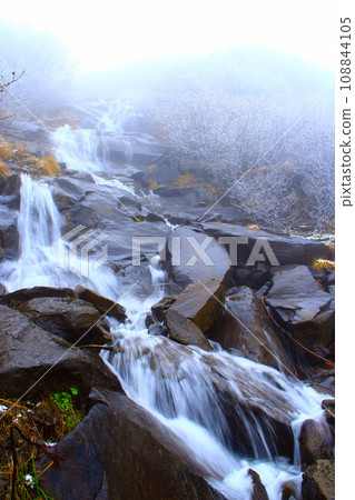 water falling from a waterfall between stones water falling from a waterfall between stones 108844105