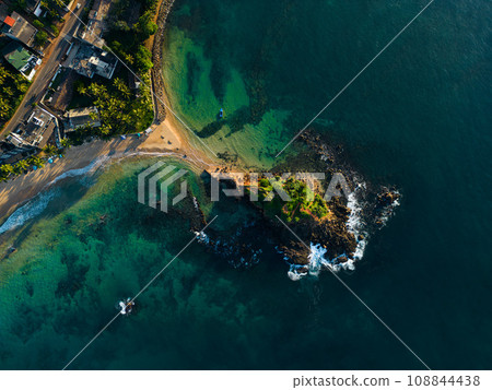 Aerial view of tranquil coastal vista with lush greenery and azure waters, ideal for travel brochures and postcards promoting serene vacations and tropical getaways. Parrot rock island in Sri Lanka. 108844438