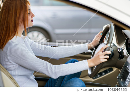 Young woman driver meditating behind a wheel of a car. 108844863
