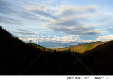 清晨,秋葉和雲彩逐漸被陽光照亮的山脈 清晨,秋葉和雲彩逐漸被陽光照亮的山脈 108844970