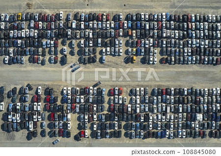 View from above of big parking lot with parked used cars after accident ready for sale. Auction reseller company selling secondhand broken vehicles for repair 108845080