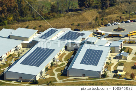 View from above of american school campus with roof covered with photovoltaic solar panels for producing of electrical clean energy View from above of american school campus with roof covered with photovoltaic solar panels for producing of electrical clean energy 108845082