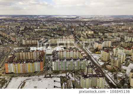 Top view of winter city landscape with tall buildings and parked cars. Drone aerial photography. Top view of winter city landscape with tall buildings and parked cars. Drone aerial photography. 108845136